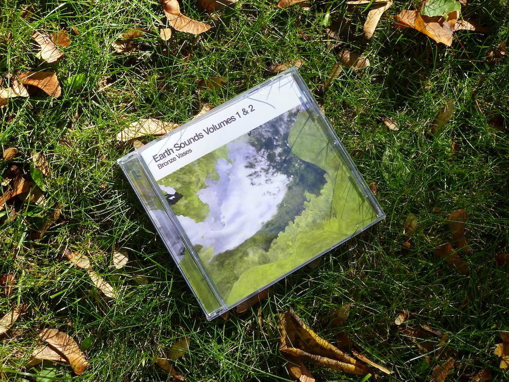 cd jewel case lying face up on grass with fall foliage